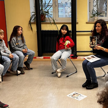 Lehrerin stellt Buch vor, Kinder sitzen im Stuhlkreis